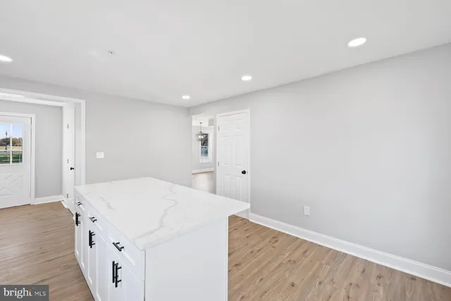 a kitchen with a sink and wooden floor