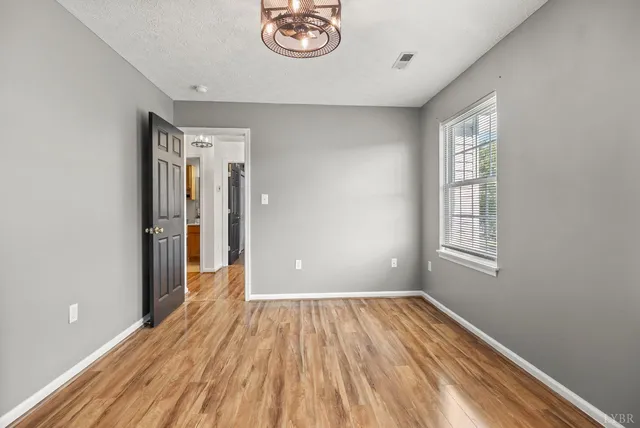 a view of a room with wooden floor and window