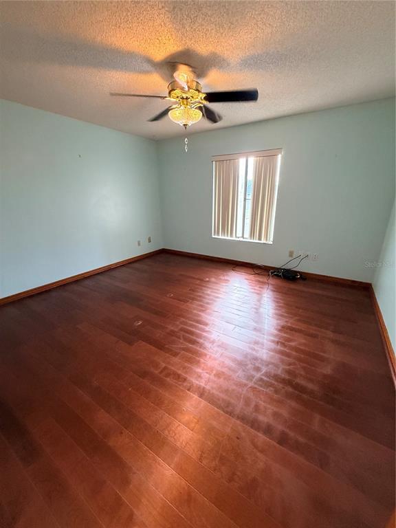 1771 Dublin Road Deltona, FL 32738 - Photo 5 of 17 an empty room with wooden floor fan and windows