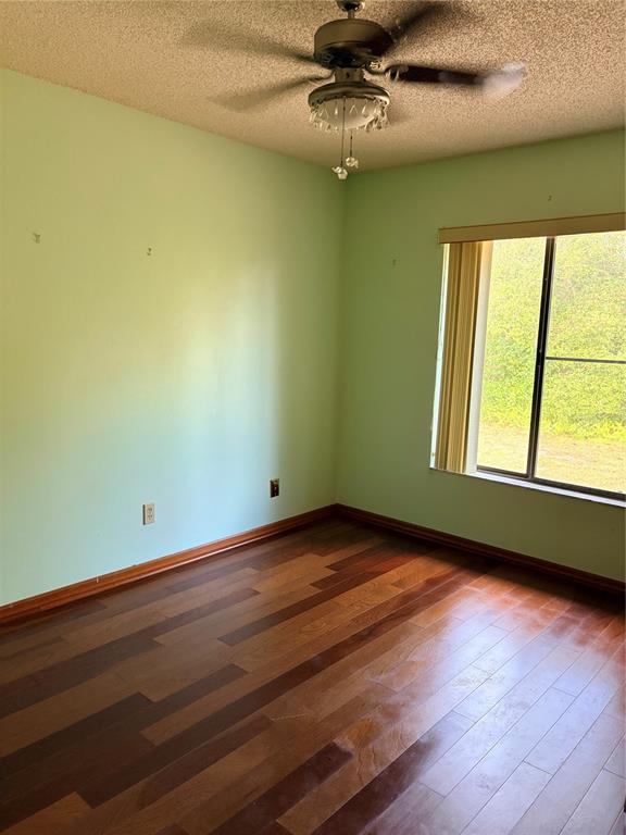 1771 Dublin Road Deltona, FL 32738 - Photo 8 of 17 an empty room with wooden floor fan and windows