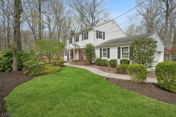 a front view of a house with a garden and outdoor seating