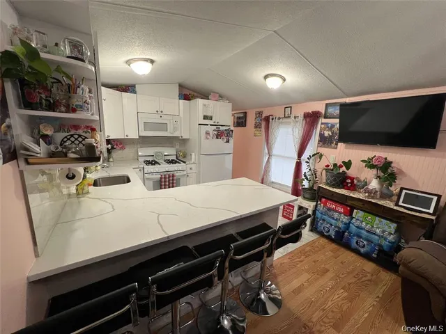 a room with stainless steel appliances kitchen island furniture and flat screen tv