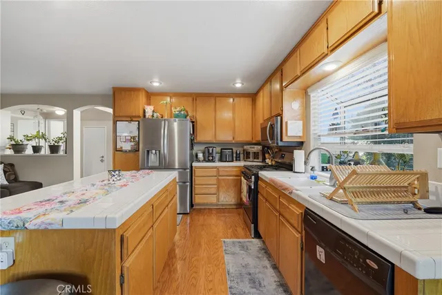 a kitchen with stainless steel appliances kitchen island granite countertop a sink stove and refrigerator