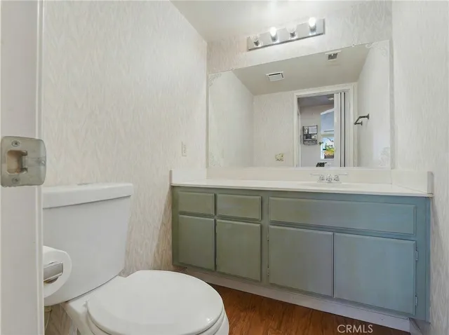 a bathroom with a toilet a sink a mirror and vanity