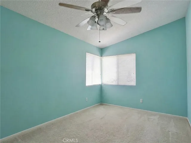 a view of a room that has a window and a ceiling fan