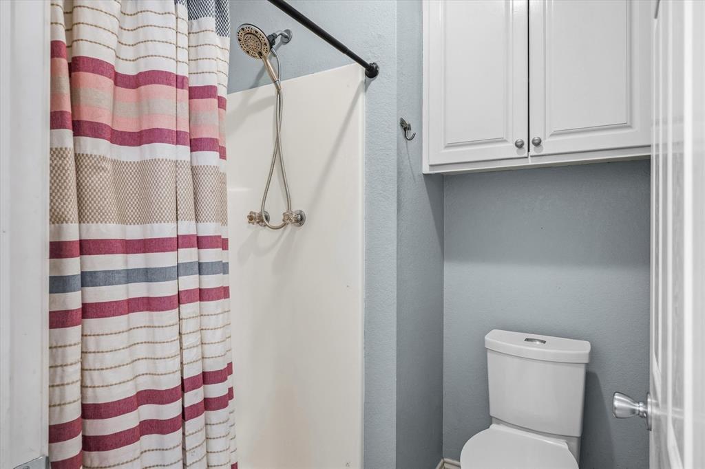 6030 Suncrest Drive Athens, TX 75752 - Photo 21 of 32 a bathroom with a toilet and a shower curtain