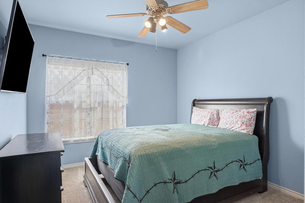 6030 Suncrest Drive Athens, TX 75752 - Photo 23 of 32 a bedroom with a large bed and a chandelier