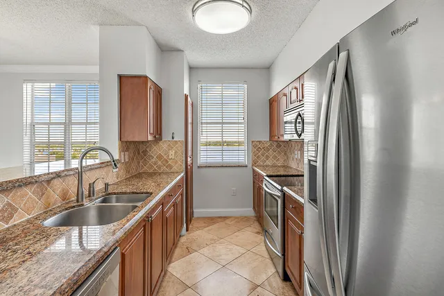 a kitchen with stainless steel appliances granite countertop a sink stove and cabinets