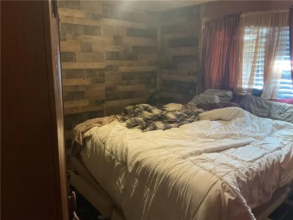 a bed sitting in a bedroom next to a window