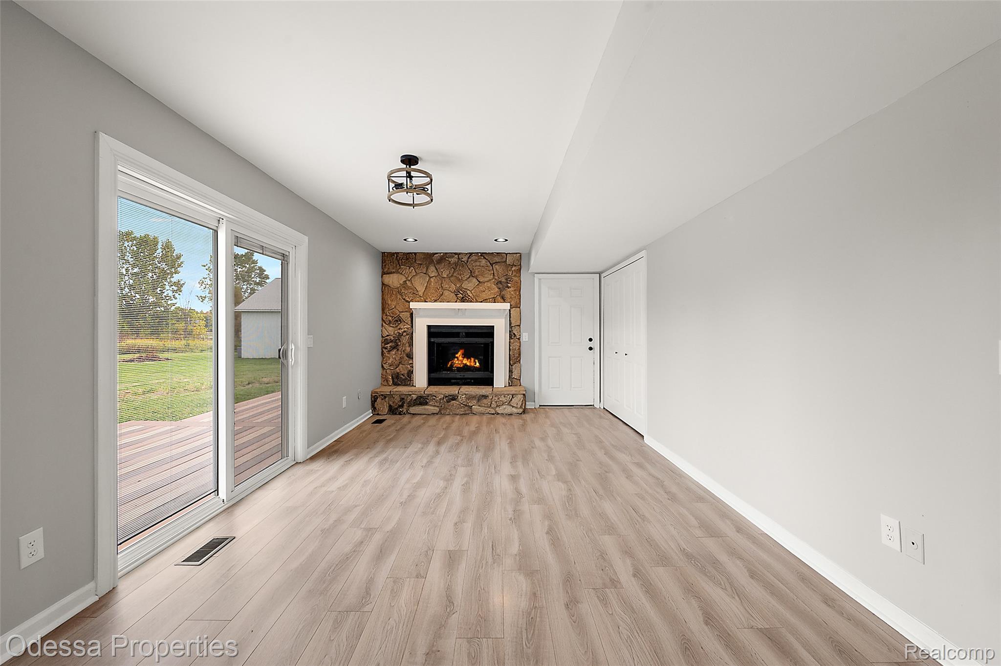 1442 Riley Center Road Memphis, MI 48041 - Photo 23 of 62 Unfurnished living room featuring a stone fireplace and light wood-type flooring