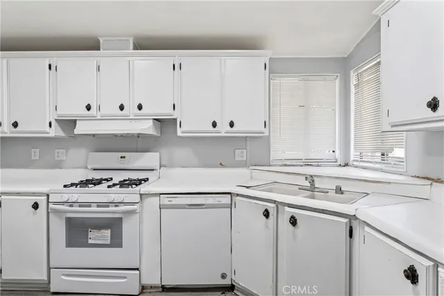 a kitchen with white cabinets and white appliances