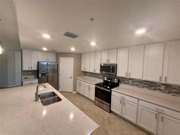 an empty room with fan and entryway