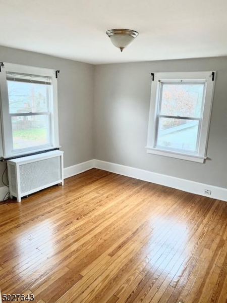 927 South Park Terrace, Unit 2 Union, NJ 07083 - Photo 4 of 12 an empty room with wooden floor and windows