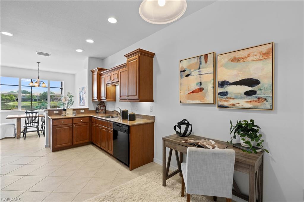 20467 Larino Loop Estero, FL 33928 - Photo 12 of 45 a large kitchen with granite countertop a stove a sink a dining table and chairs