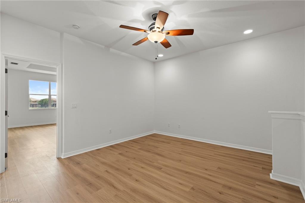 20467 Larino Loop Estero, FL 33928 - Photo 21 of 45 an empty room with wooden floor and a ceiling fan