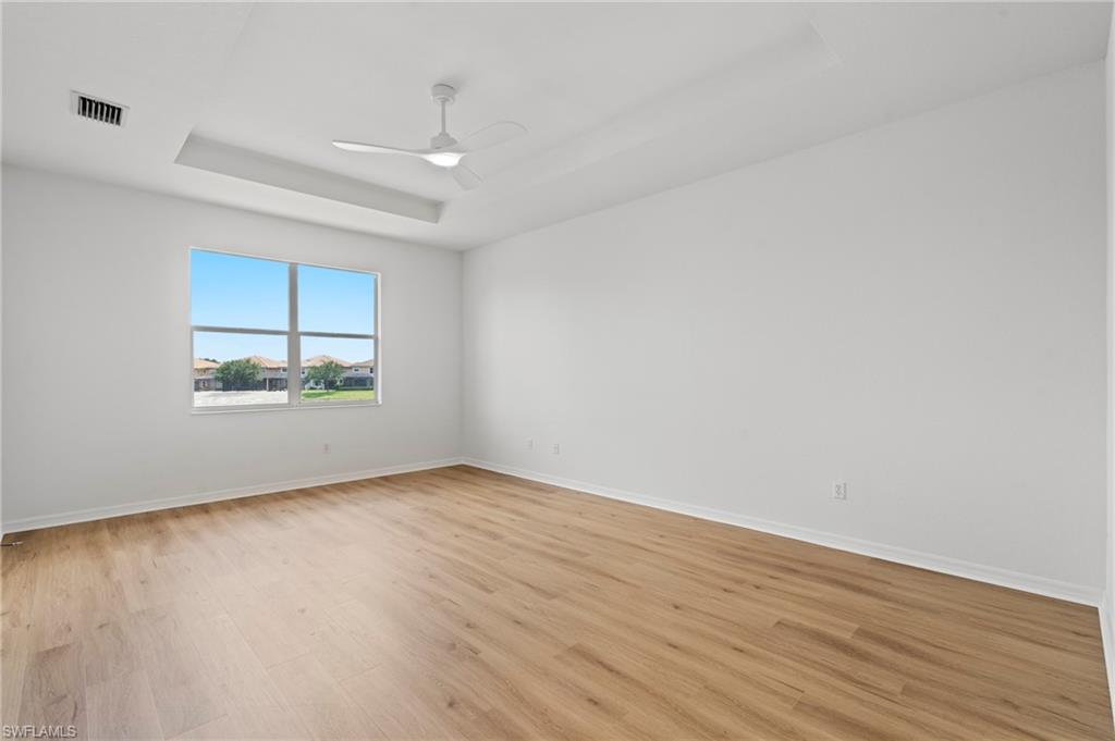20467 Larino Loop Estero, FL 33928 - Photo 22 of 45 an empty room with wooden floor and windows
