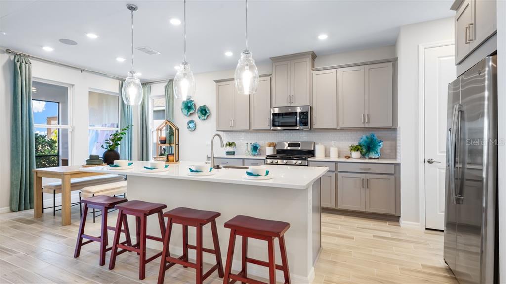 13333 Stable Place Parrish, FL 34219 - Photo 16 of 33 a kitchen with kitchen island granite countertop a sink and cabinets