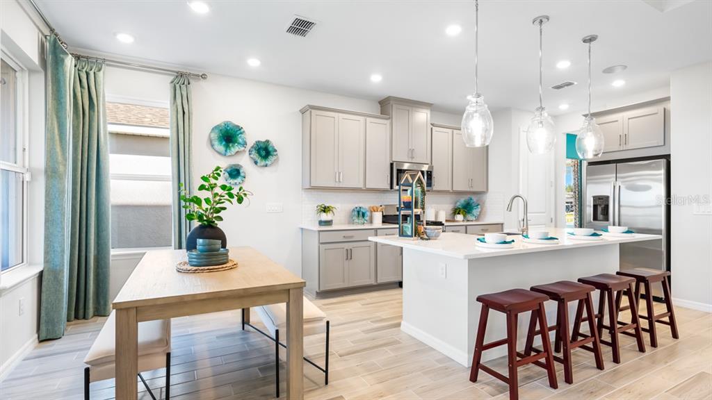13333 Stable Place Parrish, FL 34219 - Photo 19 of 33 a kitchen with kitchen island granite countertop a table and chairs in it