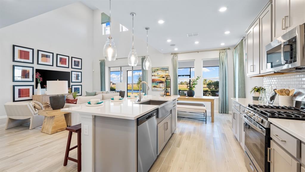 13333 Stable Place Parrish, FL 34219 - Photo 21 of 33 a large kitchen with stainless steel appliances kitchen island granite countertop a large island in the center