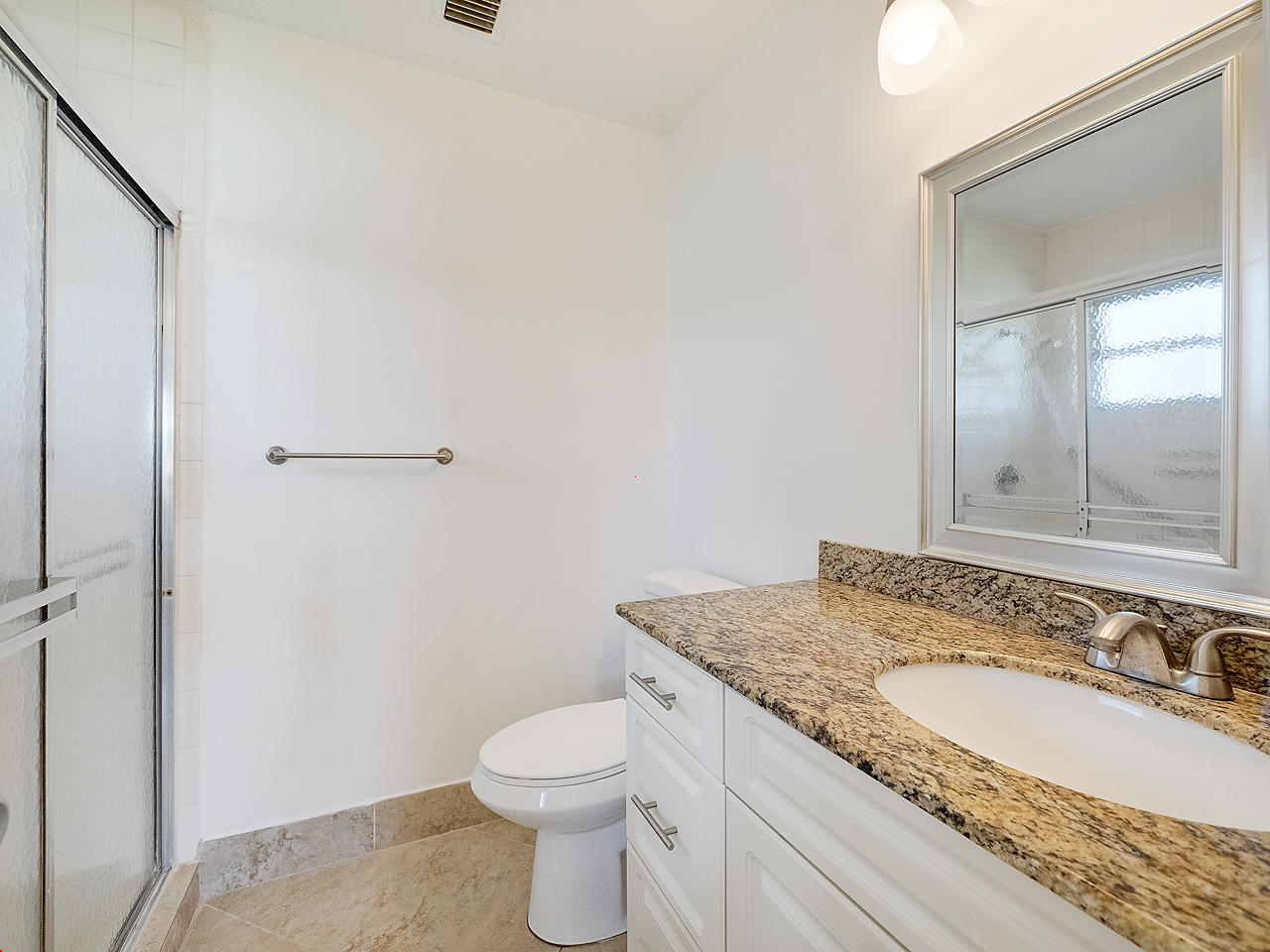 6723 Moonlit Drive Delray Beach, FL 33446 - Photo 13 of 16 a bathroom with a granite countertop sink a toilet and a mirror