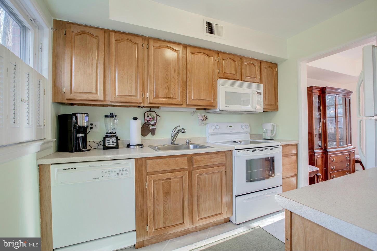 8632 Geren Road, Unit 158 Silver Spring, MD 20901 - Photo 8 of 20 a kitchen with granite countertop wooden cabinets and white appliances