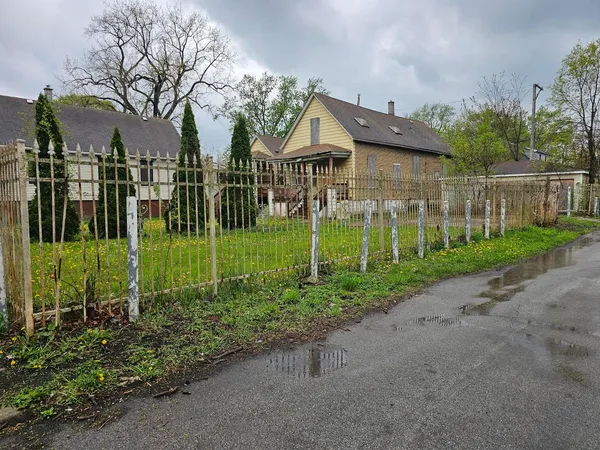 a view of a house with a big yard plants and trees