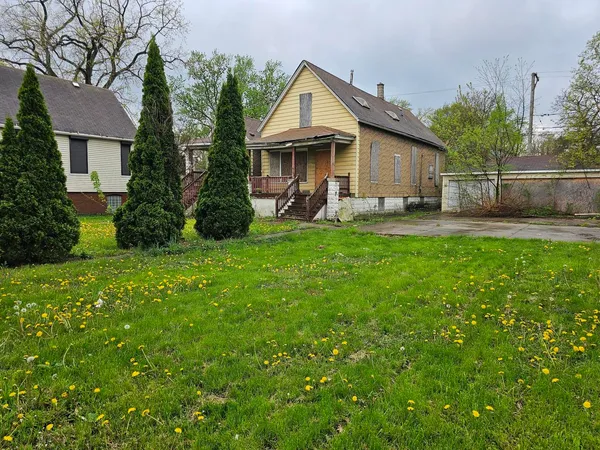 a view of a house with a yard and sitting area