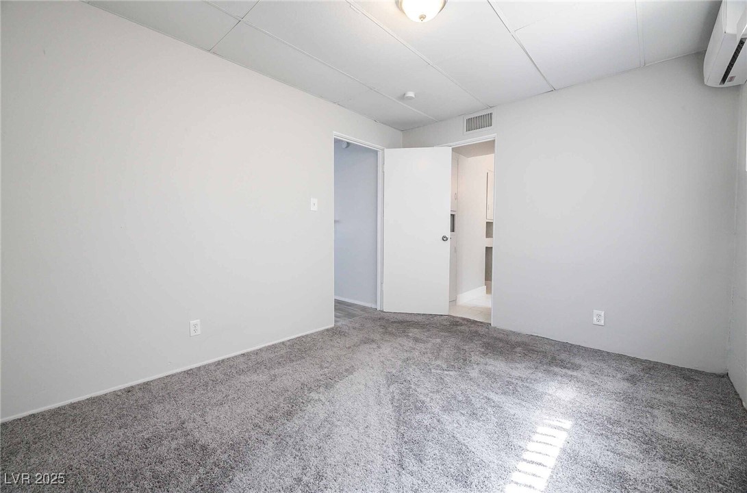 239 West Cleveland Avenue, Unit 5 Las Vegas, NV 89102 - Photo 3 of 9 Unfurnished room with an AC wall unit and carpet floors