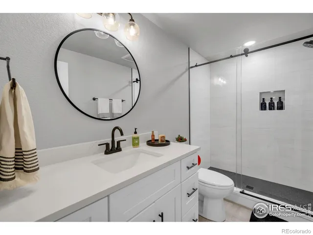 a bathroom with a sink mirror and toilet