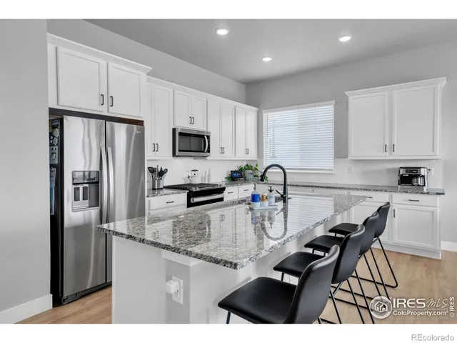 a kitchen with kitchen island a counter top space cabinets and stainless steel appliances