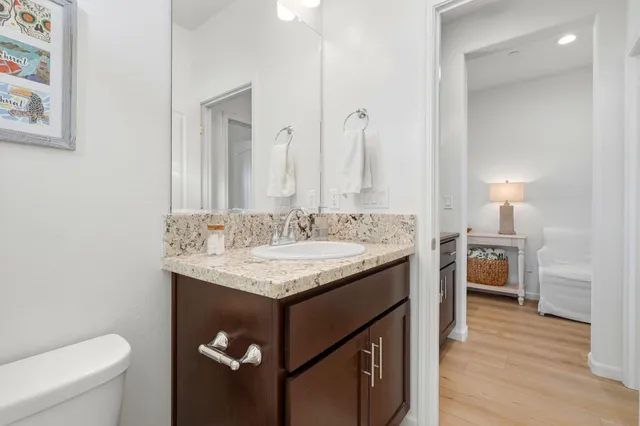 a bathroom with a granite countertop sink a toilet and a mirror