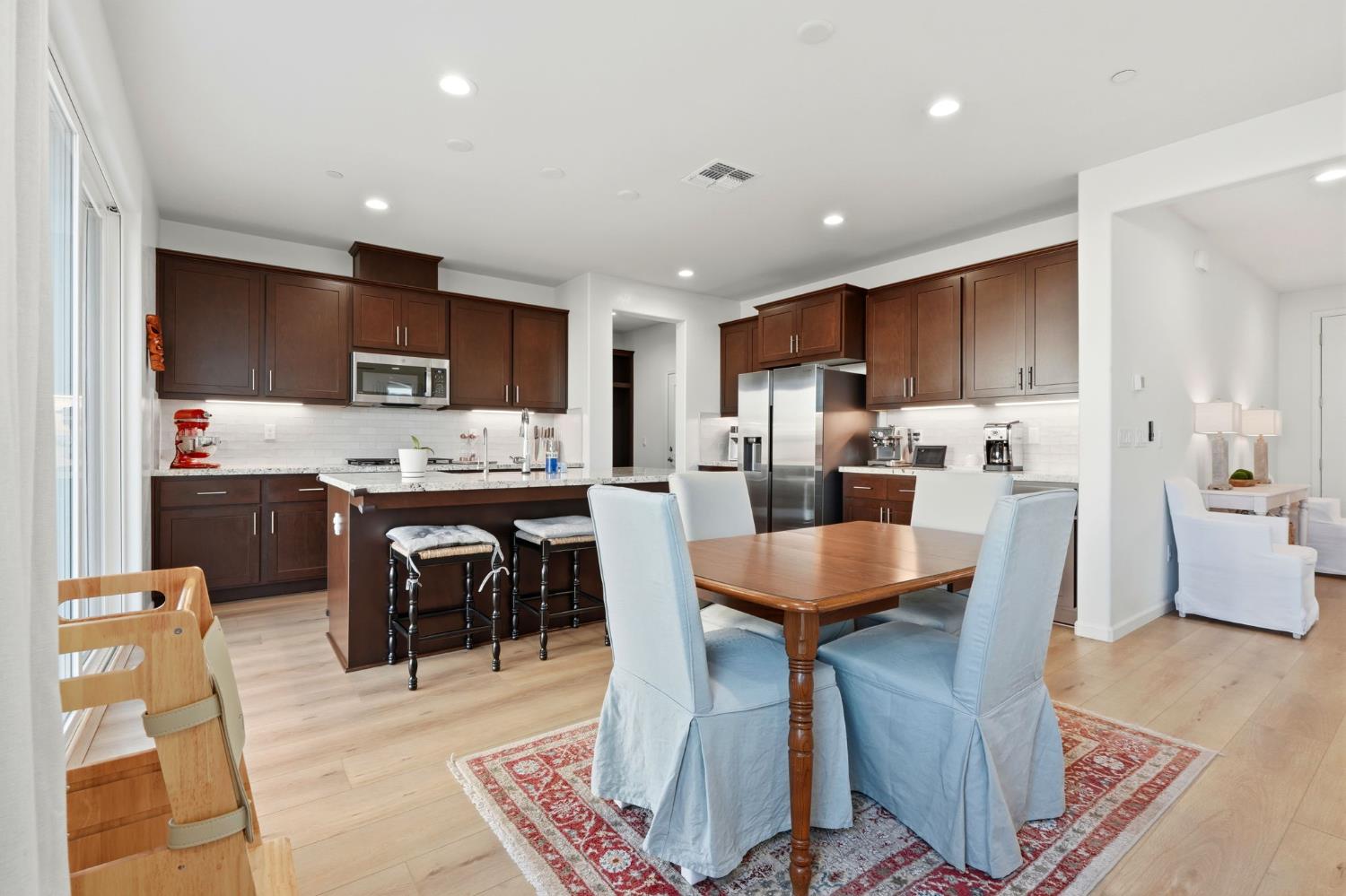 2566 Muscat Court Hanford, CA 93230 - Photo 21 of 55 a kitchen with stainless steel appliances kitchen island granite countertop a refrigerator a stove a sink a dining table and chairs