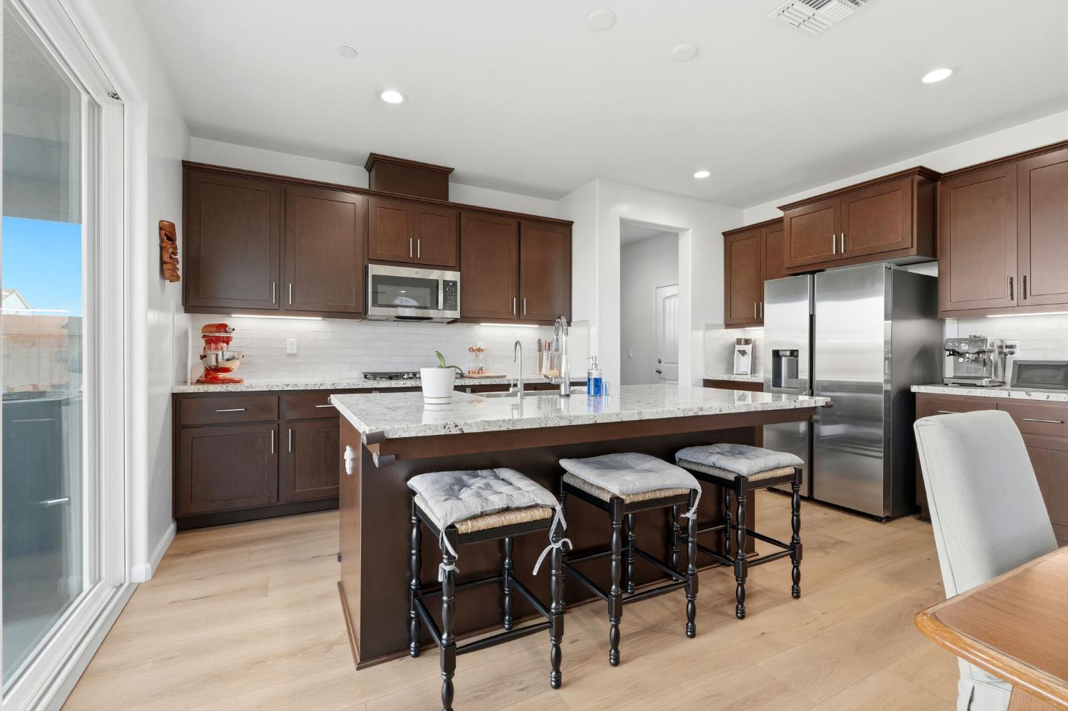 2566 Muscat Court Hanford, CA 93230 - Photo 26 of 55 a kitchen with a table chairs refrigerator and microwave