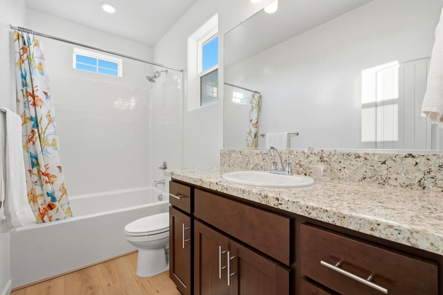 2566 Muscat Court Hanford, CA 93230 - Photo 36 of 55 a bathroom with a granite countertop sink toilet and shower
