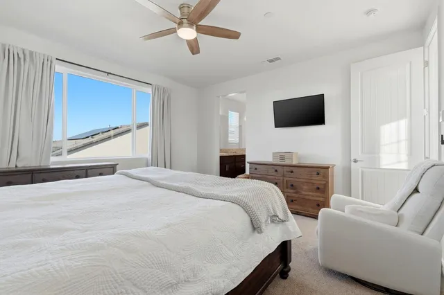 a bedroom with a bed a flat screen tv and a couch