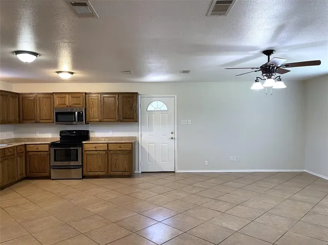 a large kitchen with a large counter top appliances and cabinets