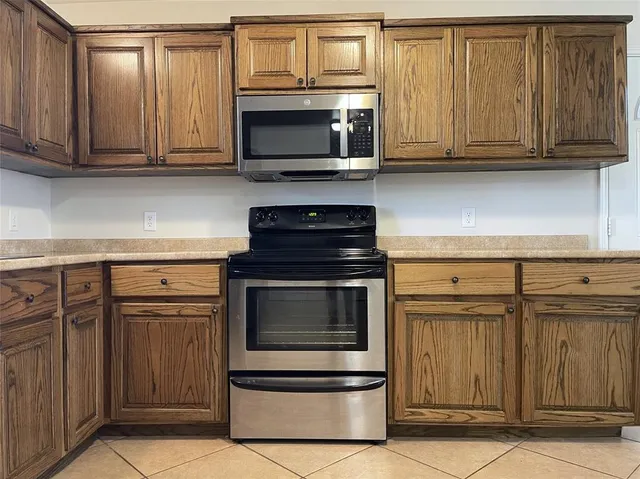 a kitchen with stainless steel appliances granite countertop a stove microwave and cabinets