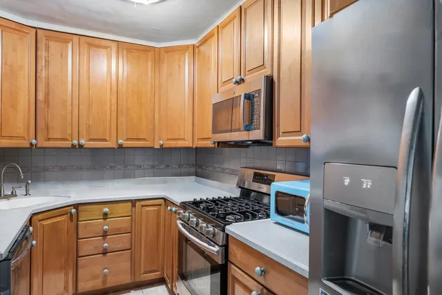 a kitchen with stainless steel appliances granite countertop a stove a sink and a microwave