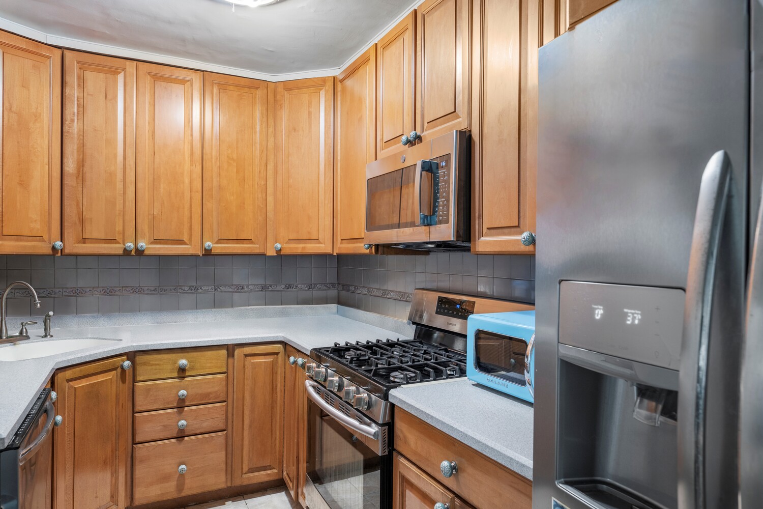 5700 Arlington Avenue, Unit 12E Bronx, NY 10471 - Photo 5 of 15 a kitchen with stainless steel appliances granite countertop a stove a sink and a microwave
