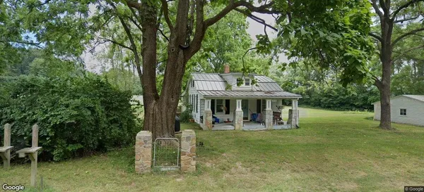 a view of a house with backyard and a tree