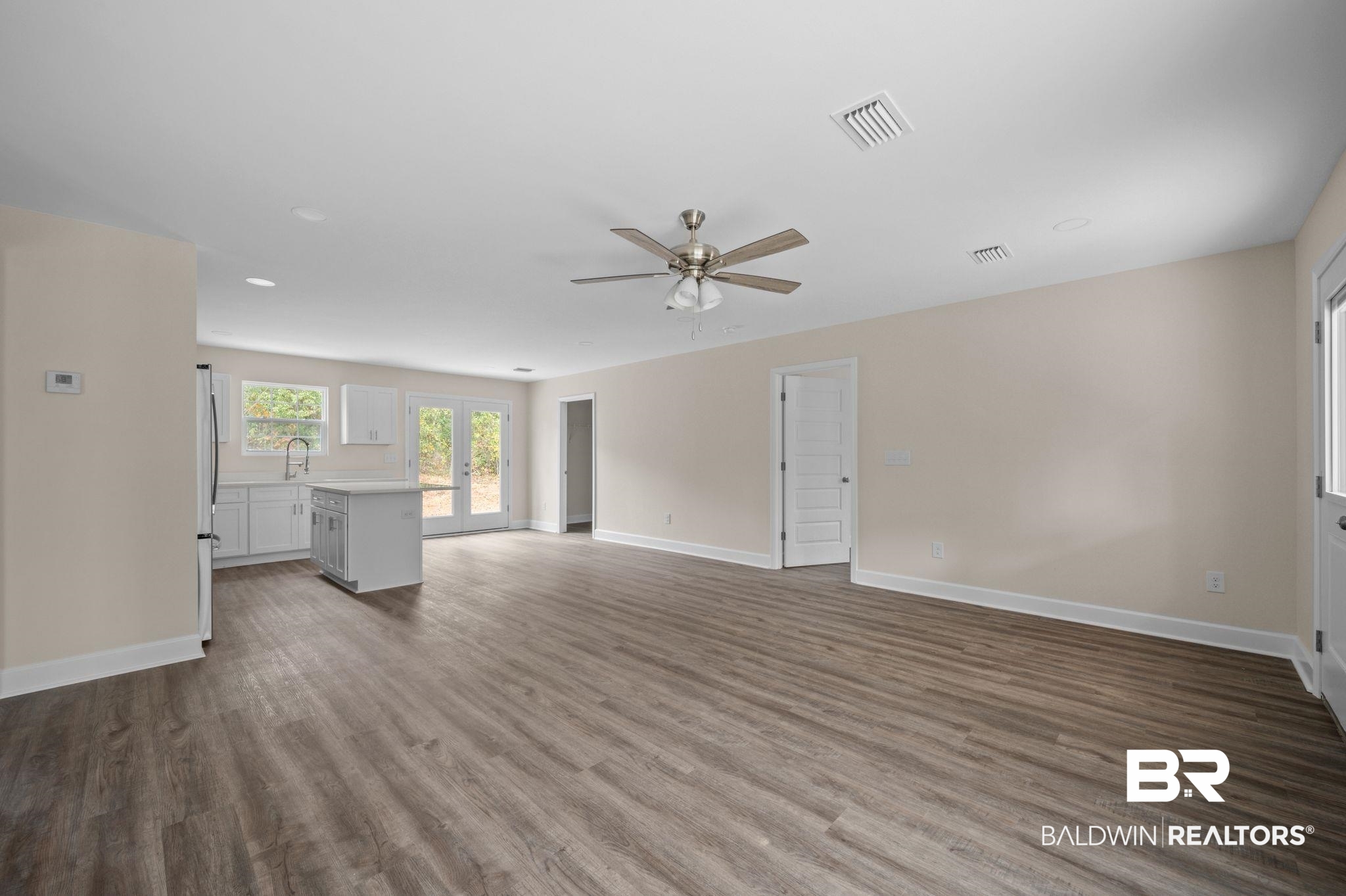 1473 Pollard Road Daphne, AL 36526 - Photo 7 of 32 Unfurnished living room with sink, hardwood / wood-style floors, ceiling fan, and french doors