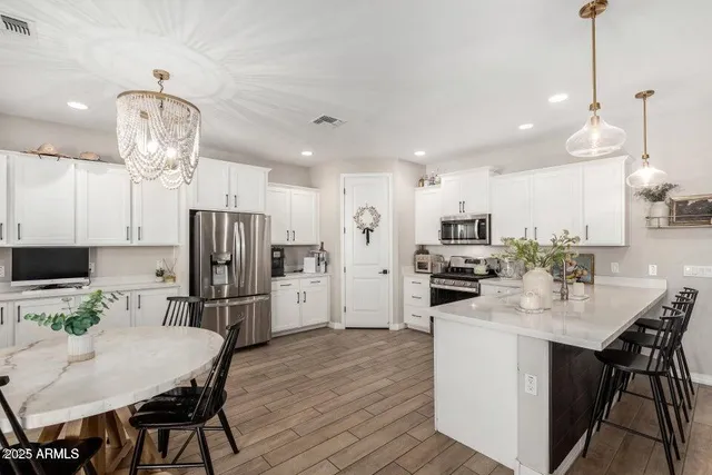 a kitchen with refrigerator a sink and chairs