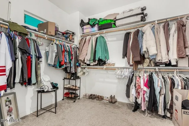 a view of walk in closet with clothes