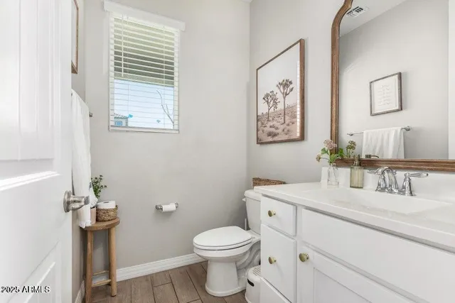 a bathroom with a toilet sink and mirror