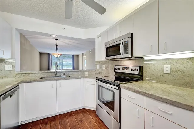 a kitchen with stainless steel appliances granite countertop a refrigerator and a stove top oven