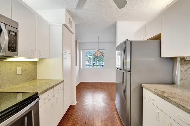 a kitchen with stainless steel appliances granite countertop a sink a stove and a refrigerator