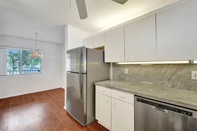 a large kitchen with a lot of counter space and wooden floor