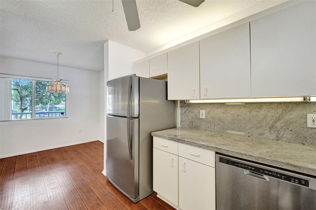 9563 Weldon Circle, Unit D212 Tamarac, FL 33321 - Photo 14 of 69 a kitchen with stainless steel appliances granite countertop a refrigerator and a sink