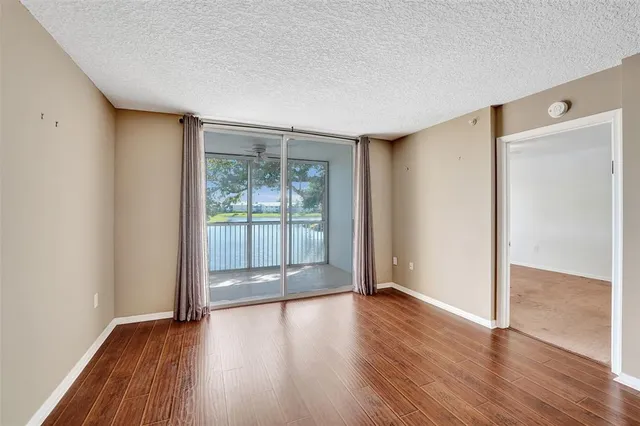 an empty room with a chandelier fan and windows