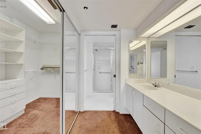 an empty room with closet and a chandelier fan